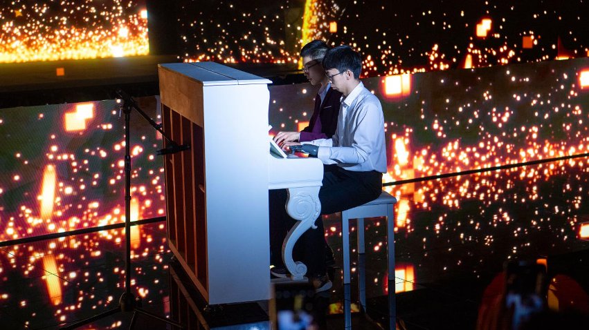 智能仿生手使用者古月與少年鋼琴家舒海峰合奏。主辦方供圖